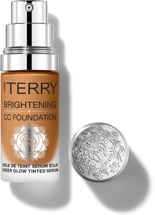 A bottle of BB Terry Brightening CC Foundation and a silver compact with a floral design.