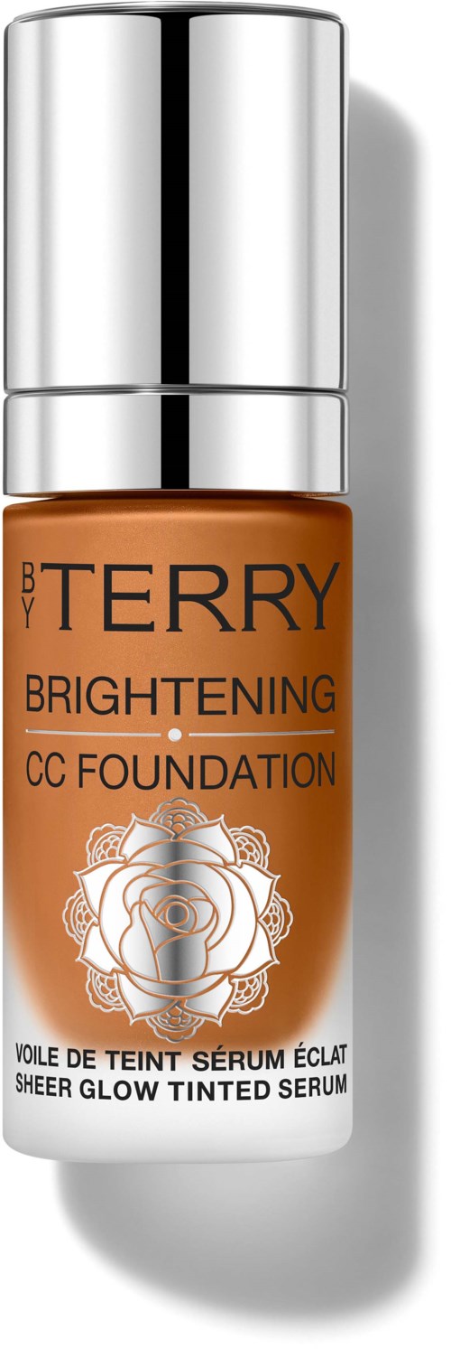 A small bottle with a silver top, orange body, and floral design. It is labeled "BY TERRY Brightening CC Foundation."