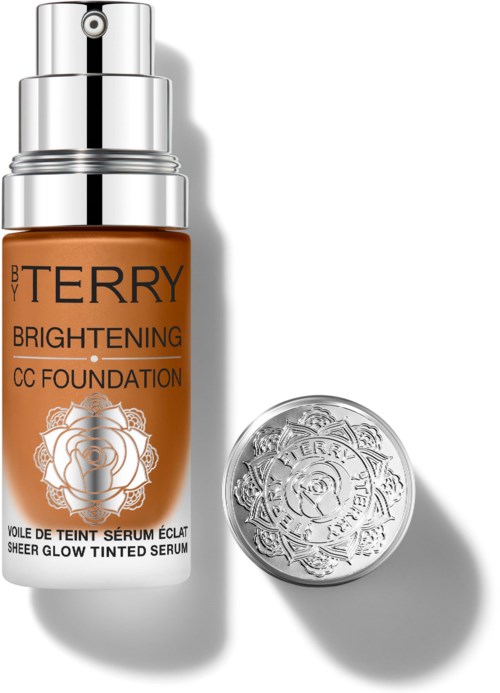 A bottle of BB Terry Brightening CC Foundation and a silver lid beside it. The bottle is orange with black and silver text.