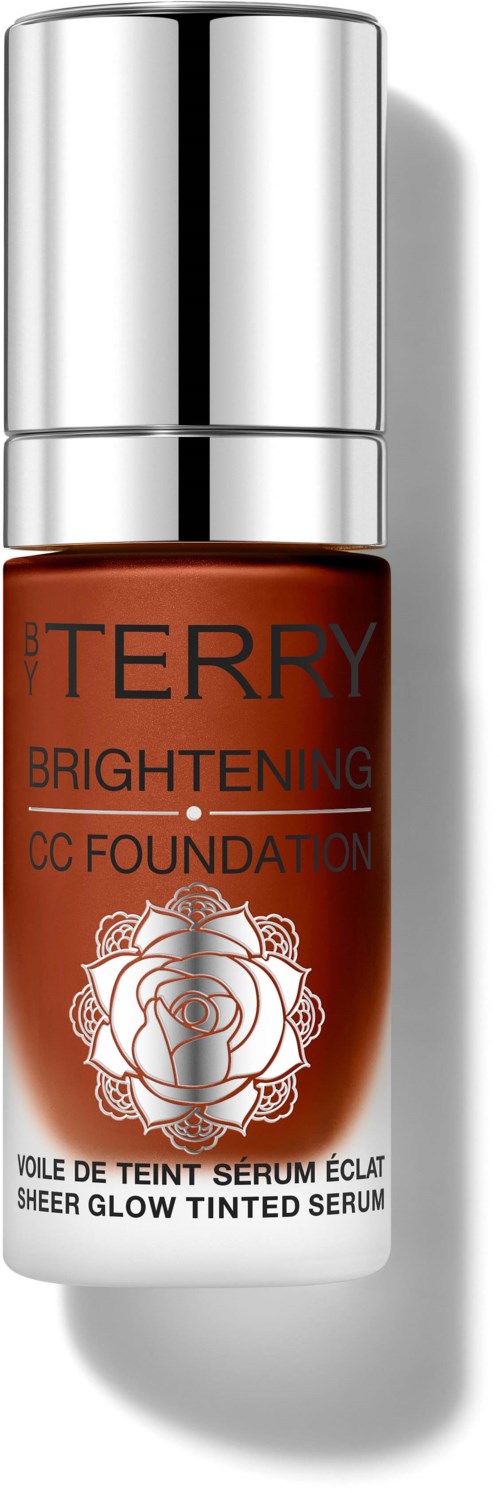 A small bottle of CC foundation with a silver cap, orange body, and a white label with a rose illustration.