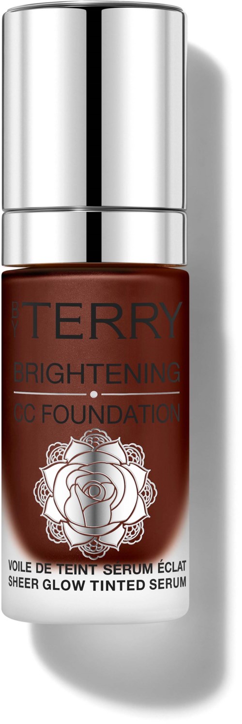 A small bottle of tinted serum with a silver cap, labeled 'TERRY Brightening Sheer Glow Tinted Serum'.