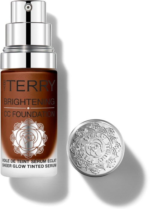 This is a brown cosmetic bottle with a silver cap and logo, and a round silver container nearby.