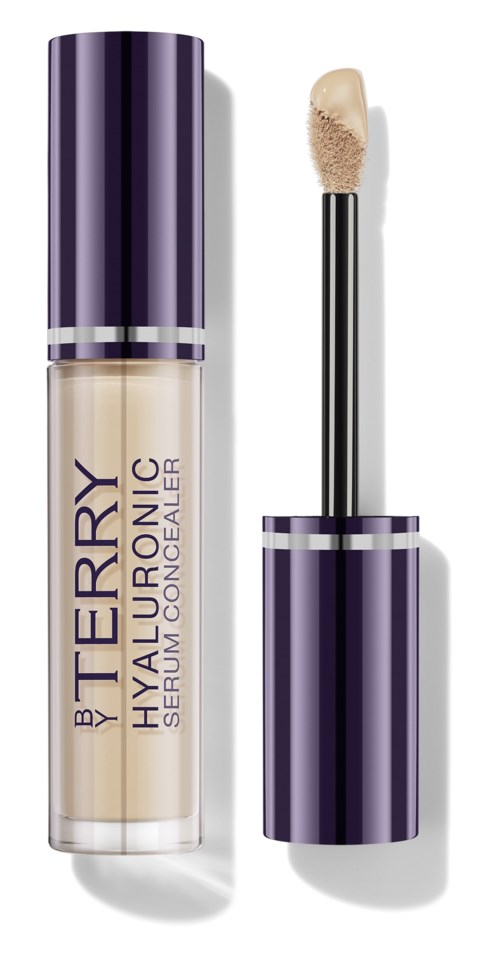 Kauneudenhoitotuote, jonka säilytysastia on violetti ja hopea, ja siinä on applicator ja tuotenimi 'By Terry Hyaluronic Serum Concealer.'