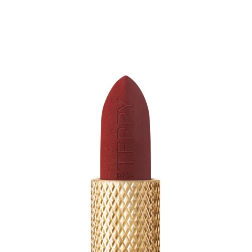 A lipstick with a red shade, housed in a gold, textured container.