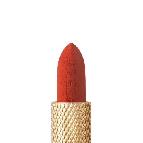 A red lipstick in a gold tube with a textured pattern. The lipstick is slightly tilted upward.