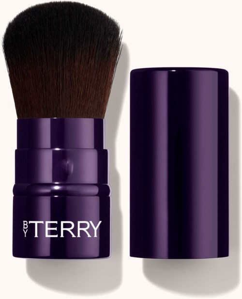 A dark purple makeup brush with a large, fluffy bristle head, and a matching cylindrical cover.