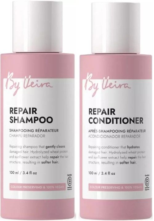 To rosa flasker med reparasjonssjampo og balsam med hvite lokk, merket med merke og produktdetaljer.