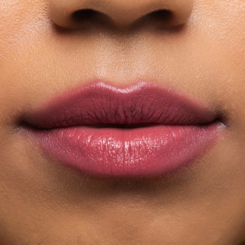 Close-up van roze lippen en deel van de neus op gladde huid.