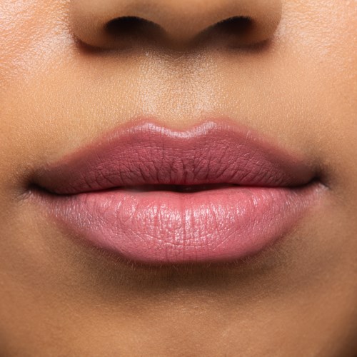 Close-up of lips with smooth, light pink skin and natural shape.