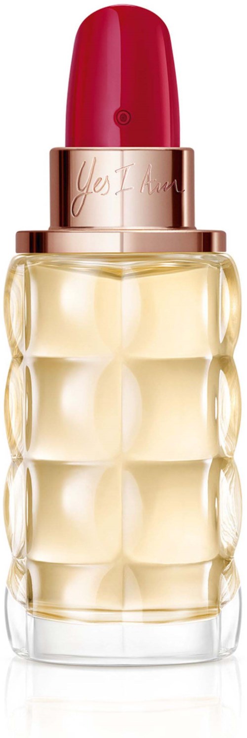Ein Parfümflasche mit rotem Deckel, roségoldenem Band und klar strukturiertem Glasbehälter. Enthält hellgelbe Flüssigkeit.