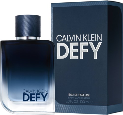 Een Calvin Klein Defy parfumfles naast de doos, beide donkerblauw met witte tekst, groot en slank ontwerp.