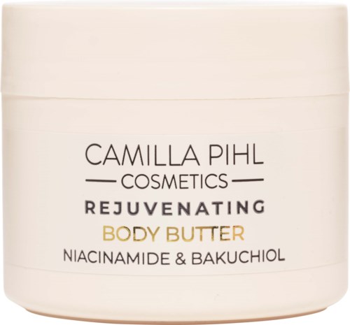 Een witte pot met zwarte en gouden tekst voor Camilla Pihl cosmetisch lichaamsboter, vermeldt ingrediënten zoals niacinamide en bakuchiol.