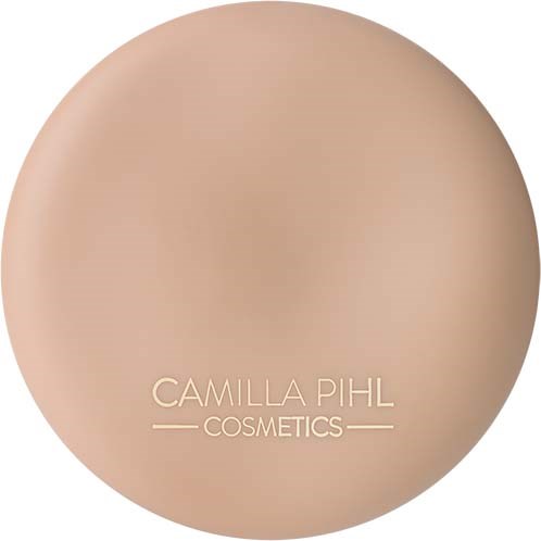 Eine runde beige Make-up-Grundierungsschachtel mit dem Markennamen Camilla Pihl Cosmetics.