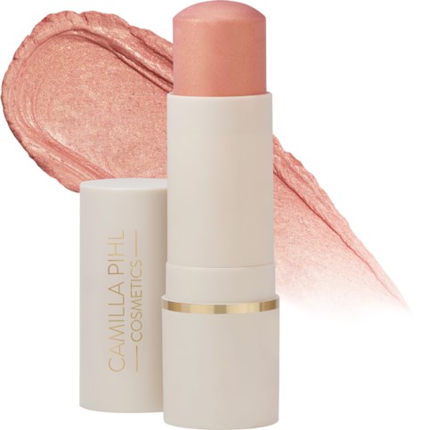 Een lippenstift met roze tint en witte verpakking met gouden details, met een roze waas erachter.
