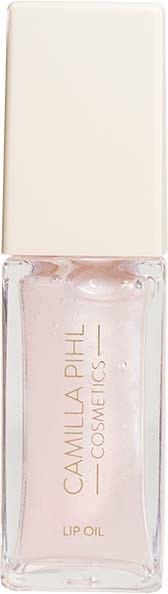 Eine klare Glasflasche mit weißem Deckel, gekennzeichnet als Camilla Pihl Lip Oil, enthält rosa Flüssigkeit.