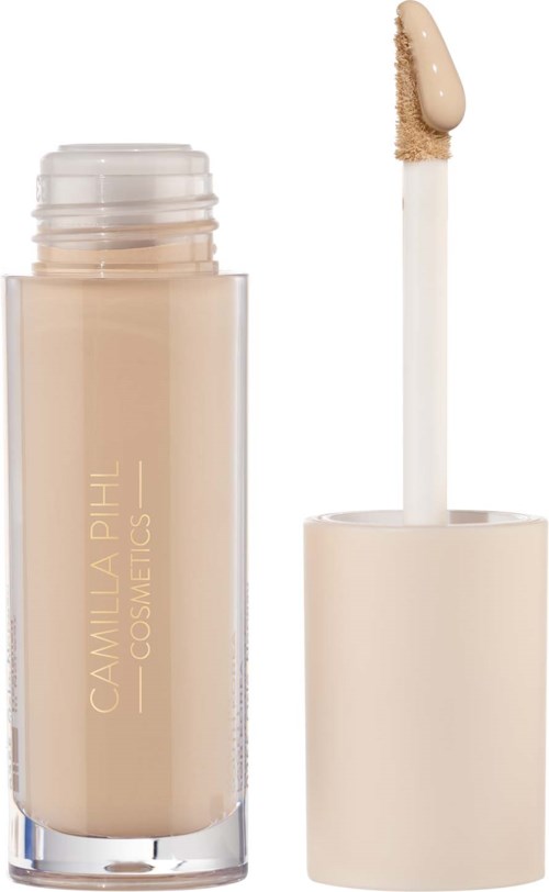 Ein beiger Concealer-Stick mit weißem Deckel, zeigt den Applikator mit Produkt und den Markennamen Camilla A Till.