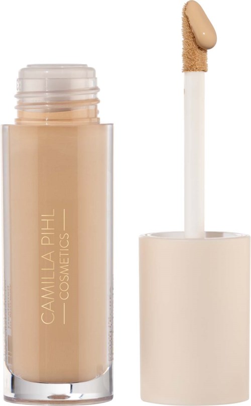 Beige flüssiger Foundation mit weißem Deckel und Applikatorspachtel. Die Flasche trägt den Namen 'Camilla Pihl Cosmetics'.