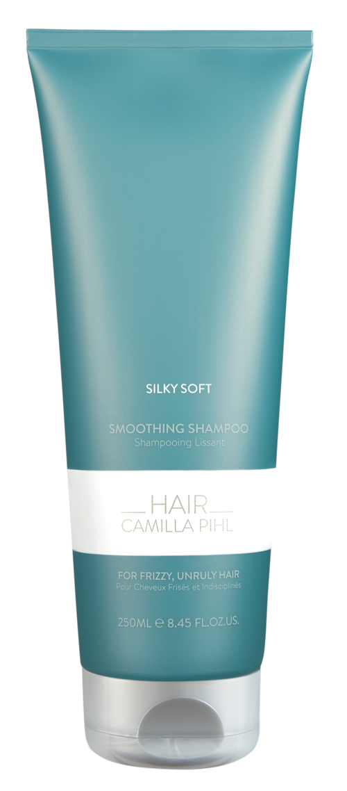Een blauwe en witte fles met shampoo getiteld "Silky Soft" voor kroes en onhandig haar.