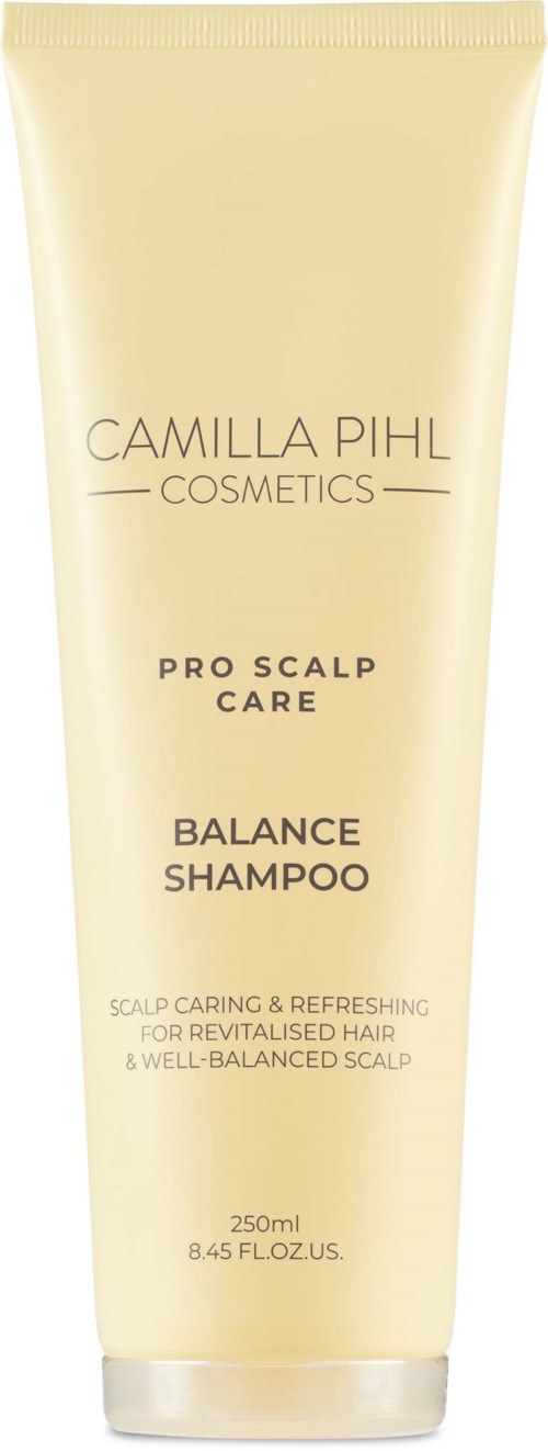 En lys gul tube med Camilla Pihl Cosmetics Balance Shampoo med svart text, 250 ml.