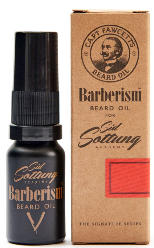 A small black bottle of beard oil next to a brown box with a drawing of a bearded man and the words 'Barberism Beard Oil.'