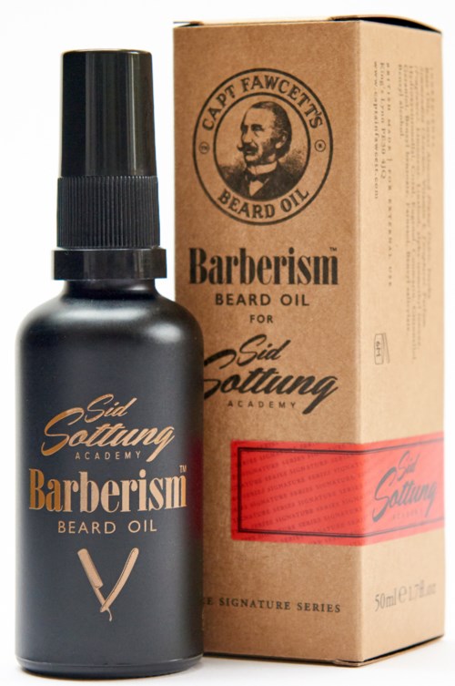 A black bottle of beard oil next to a brown cardboard box with a man's face logo and text.