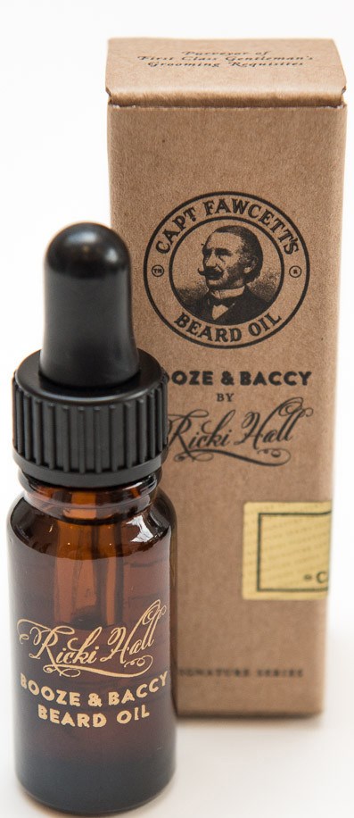 A small brown bottle with a dropper cap next to a beige box, both labeled 'Ricki Hall Booze & Baccy Beard Oil.'