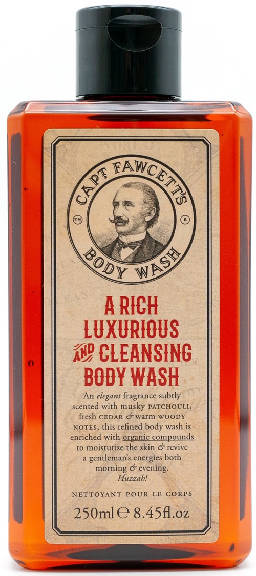 An orange bottle of body wash with a black cap. The label features a man's face and text describing a luxurious cleansing product.