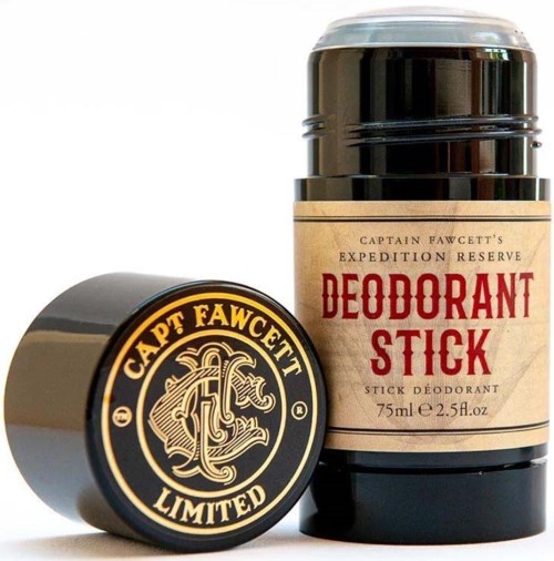 A deodorant stick container with a beige label and red text, next to a round lid with a black and gold logo.