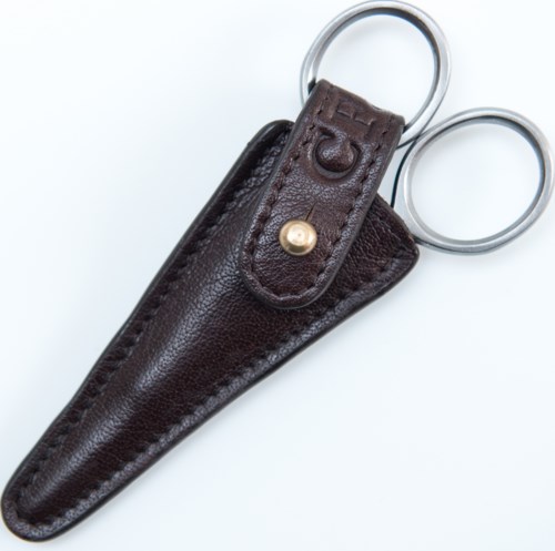 A leather key case with a ring, a strap with a button, and the letters 'G' and 'E' embossed.