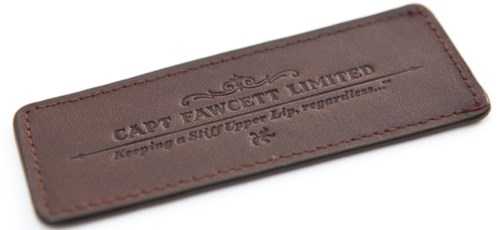 A brown leather label with the text 'CAPE TAWOIT LIMITED' and some smaller unreadable text. It has stitched edges.