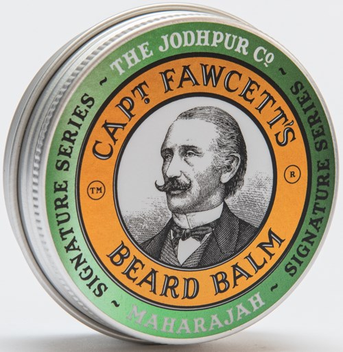 A round tin with a man's portrait, green and orange labels, and text about beard balm and grooming.