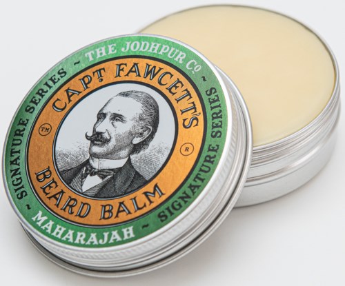A tin of beard balm with a label featuring a man with a mustache and text about a signature series.