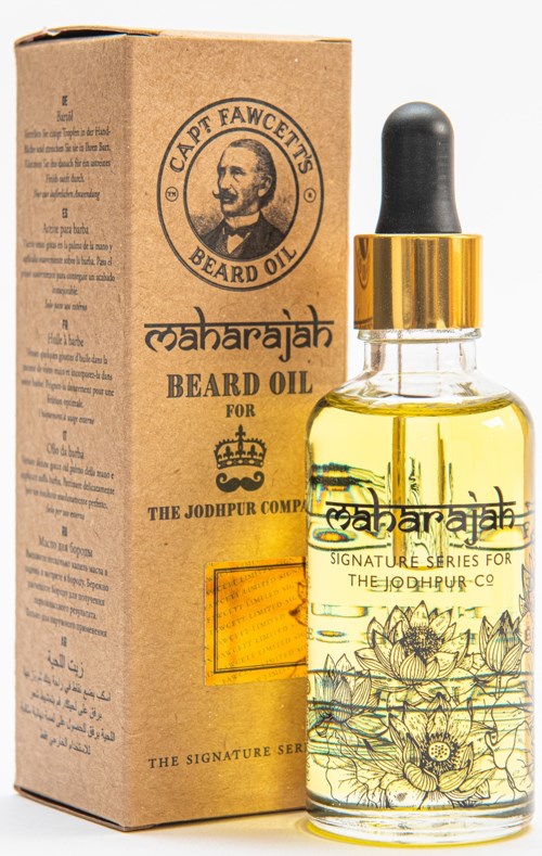 A small glass bottle of beard oil next to a cardboard box with a portrait of a man. The label says 'Maharajah Beard Oil.'