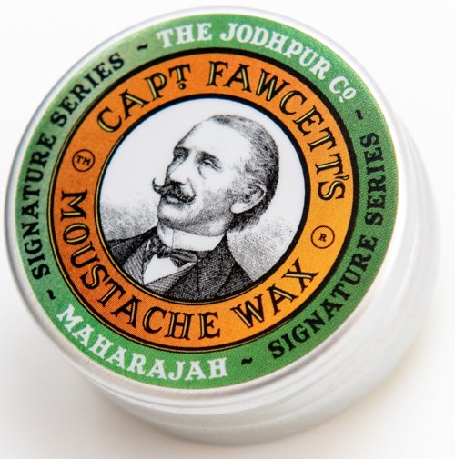A round container with a label showing a man's portrait and words about a signature series and hair wax.