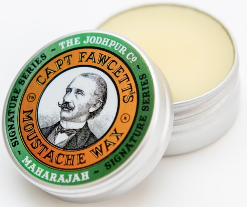 A round tin of Mustache Wax with a label featuring a man's portrait and text about a signature series.