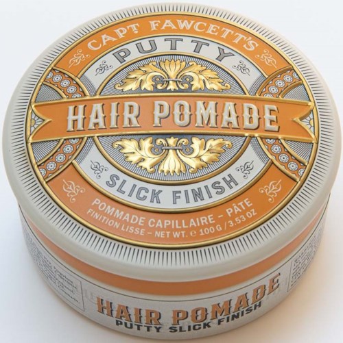 A round tin container labeled 'Hair Pomade' with decorative gold and silver designs, mentioning 'Putty' and 'Slick Finish'.