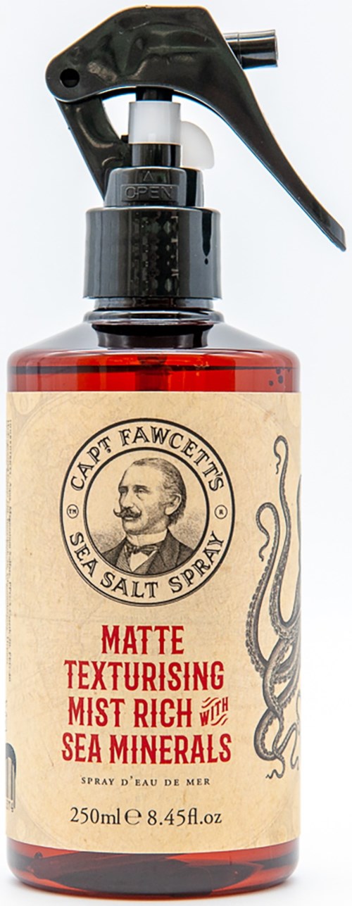 A spray bottle labeled 'Sea Salt Spray' with a black trigger, containing sea minerals and designed for hair styling.