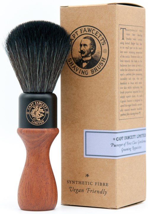 A shaving brush with black bristles, wooden handle, and a brand logo, next to a cardboard box labeled for the brush.