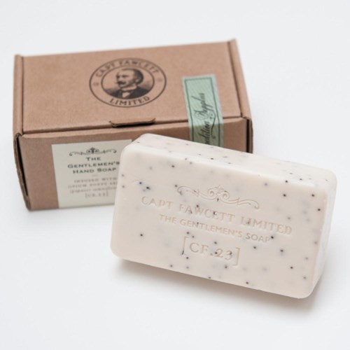 En hvit såpe med svarte prikker og en brun eske merket 'The Gentlemen's Soap' med en logo av et mansansikt.