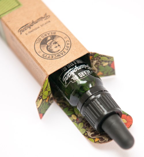 A small dark glass bottle with a dropper opens from a decorative box, labeled 'caru ulaund'.