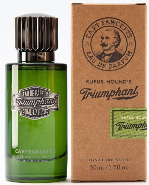A green perfume bottle with a black cap next to a brown box with text and a portrait. The bottle is labeled 'Triumphant.'
