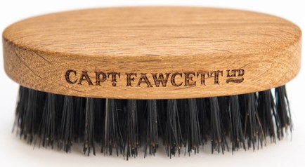 En groomingborste med handtag av trä, svarta borststrån och märket 'CAPT FAWCETT LTD' ingraverat.
