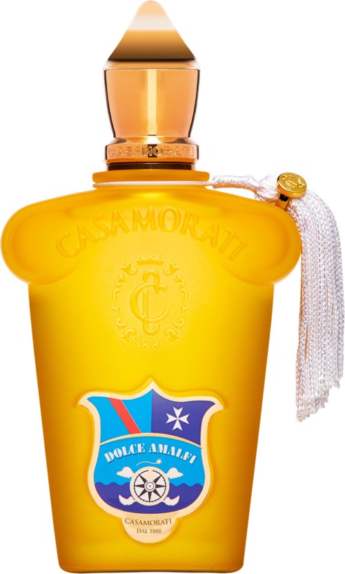 A yellow perfume bottle with a gold cap, a blue shield label, and a white tassel attached.