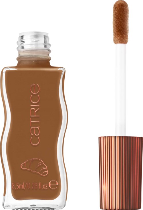 A foundation bottle with a metallic cap and a doe-foot applicator with brown foundation on it.