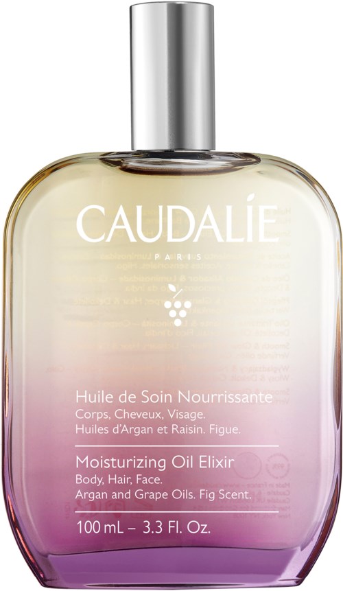 A large, elegant bottle of Caudalie moisturizing oil elixir with a silver cap, light purple gradient at the bottom.