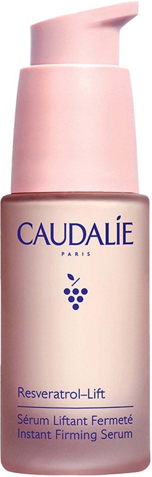 A pink bottle of Caudalie Resveratrol-Lift serum with a pump. The label shows the brand name and product details.
