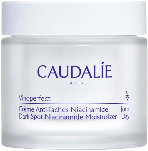 A white jar with blue text describing a dark spot moisturizer for nighttime use.