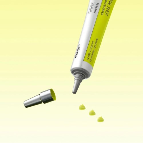 A yellow tube of skin treatment cream with a gray cap and small dollops on a yellow background.