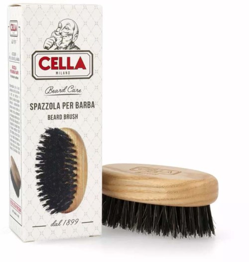 A beard brush with black bristles next to a white box with red and black text, and a cartoon man logo.