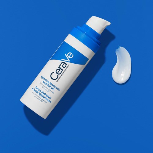 Een blauw-witte fles CeraVe moisturizer met een toefje crème op een blauwe achtergrond.
